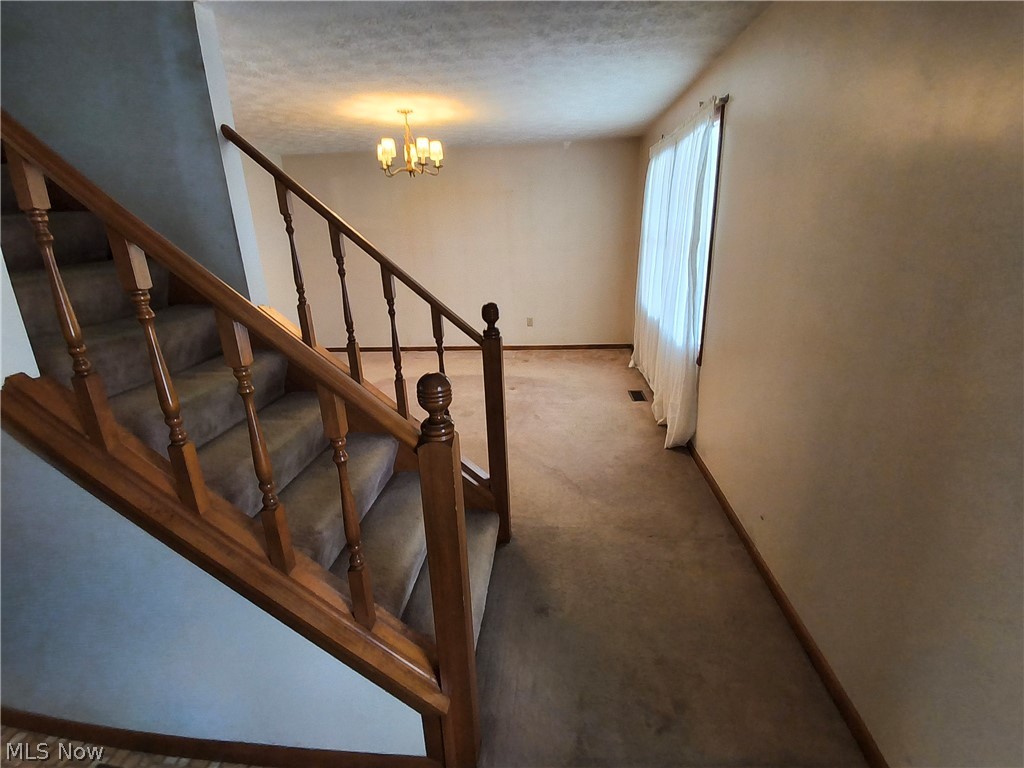 2672 Crackel Road Aurora, OH 44202 - Photo 29 of 38 Stairway with a chandelier and carpet flooring
