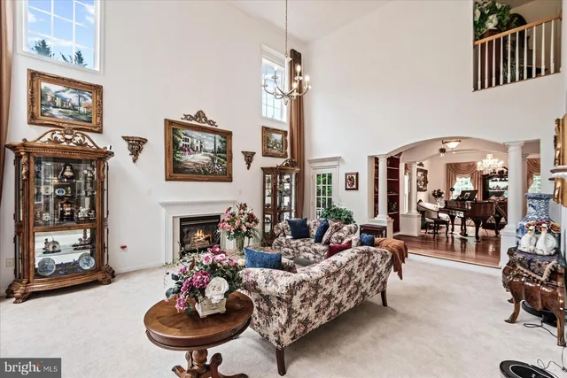 a living room with furniture a flat screen tv and a chandelier