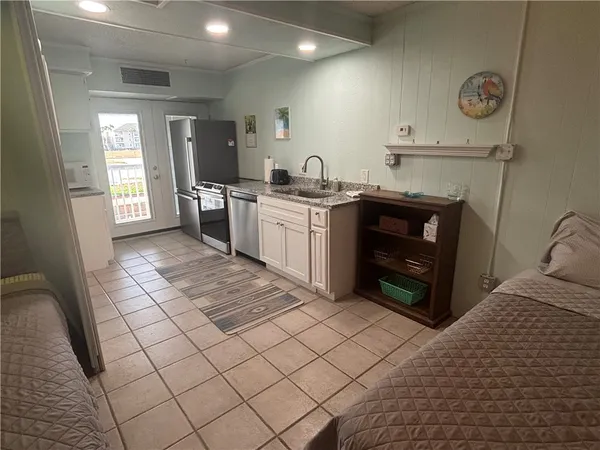 a kitchen with stainless steel appliances granite countertop a stove a sink and a refrigerator