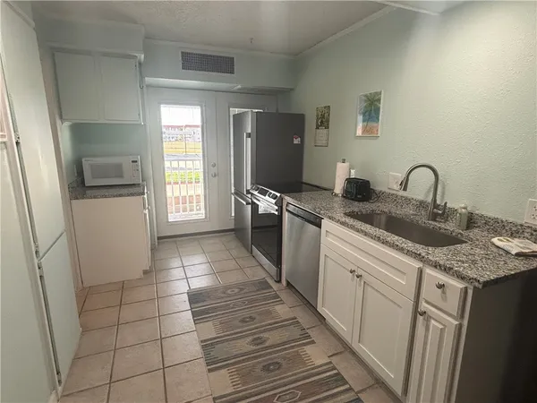 a kitchen with stainless steel appliances granite countertop a sink and a stove top oven