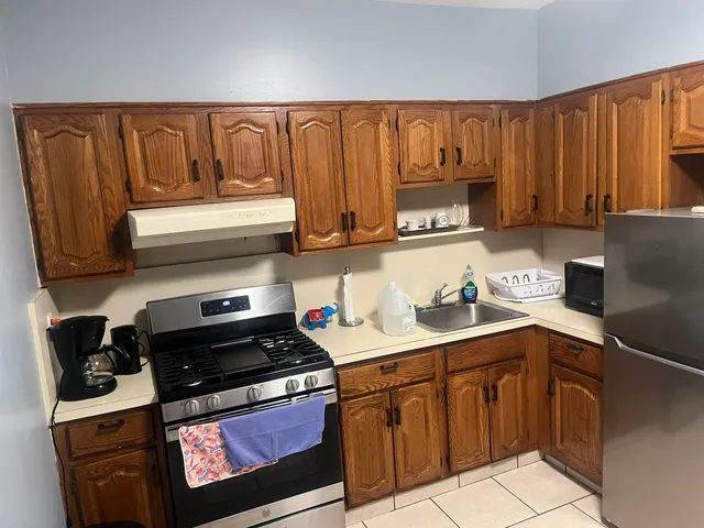 a kitchen with stainless steel appliances granite countertop a refrigerator and a stove top oven