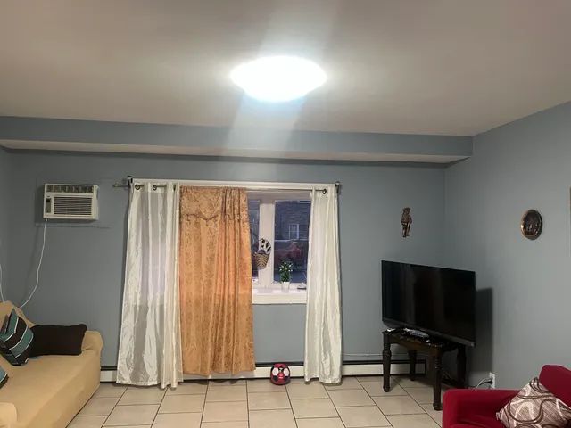 a living room with a flat screen tv and a window