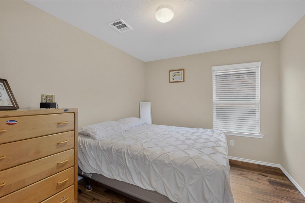 1409 Slate Street Princeton, TX 75407 - Photo 23 of 36 Neutral-toned walls complement the wood-finish flooring