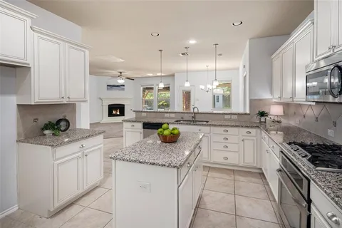 a kitchen with stainless steel appliances granite countertop a stove a sink and a granite counter tops