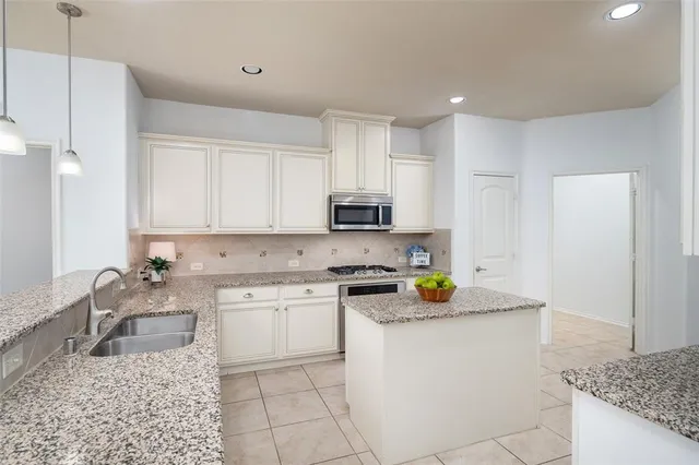 a kitchen with stainless steel appliances granite countertop a sink stove and cabinets