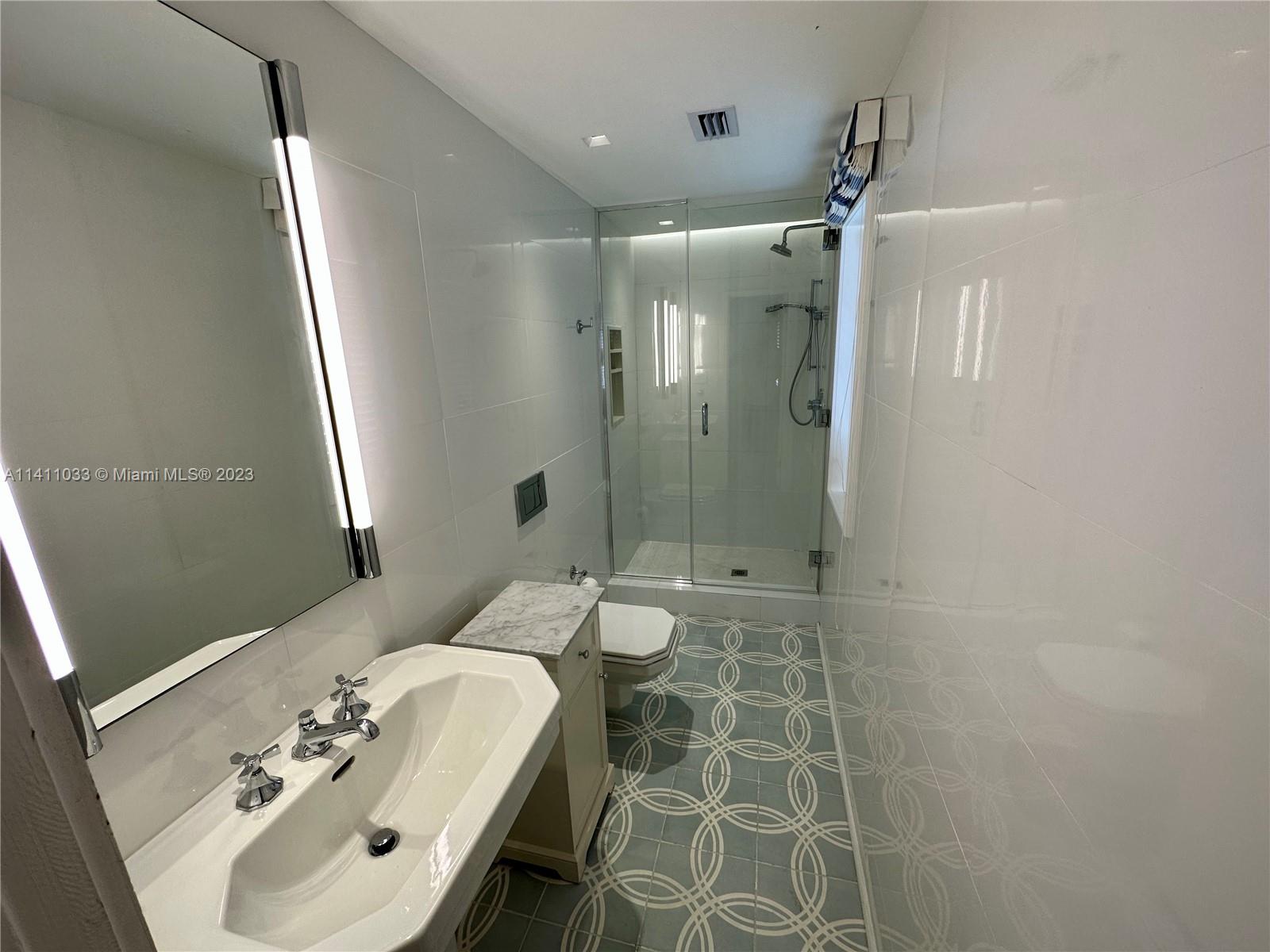 Mid Beach Miami Beach, FL 33140 - Photo 15 of 40 a bathroom with a sink shower and a mirror