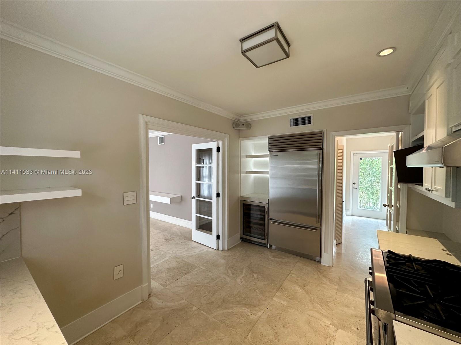 Mid Beach Miami Beach, FL 33140 - Photo 35 of 40 a kitchen with stainless steel appliances kitchen island granite countertop a refrigerator and a stove
