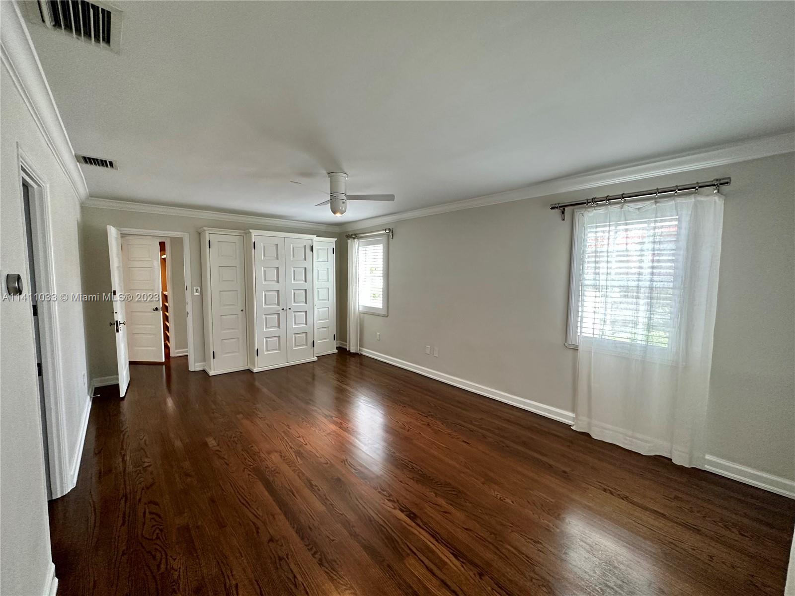 Mid Beach Miami Beach, FL 33140 - Photo 8 of 40 an empty room with wooden floor and windows