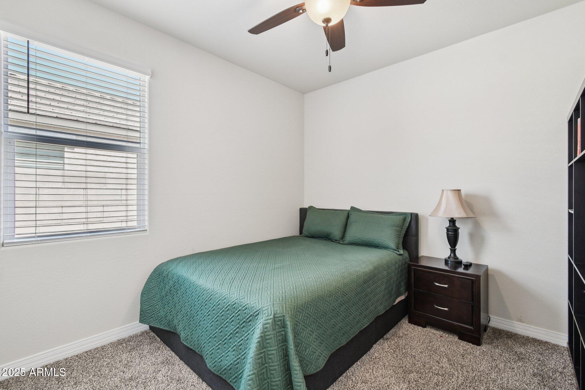 18819 West Farmer Road Buckeye, AZ 85326 - Photo 13 of 23 a bedroom with a bed and a window