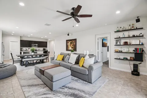 a living room with furniture kitchen view and a chandelier