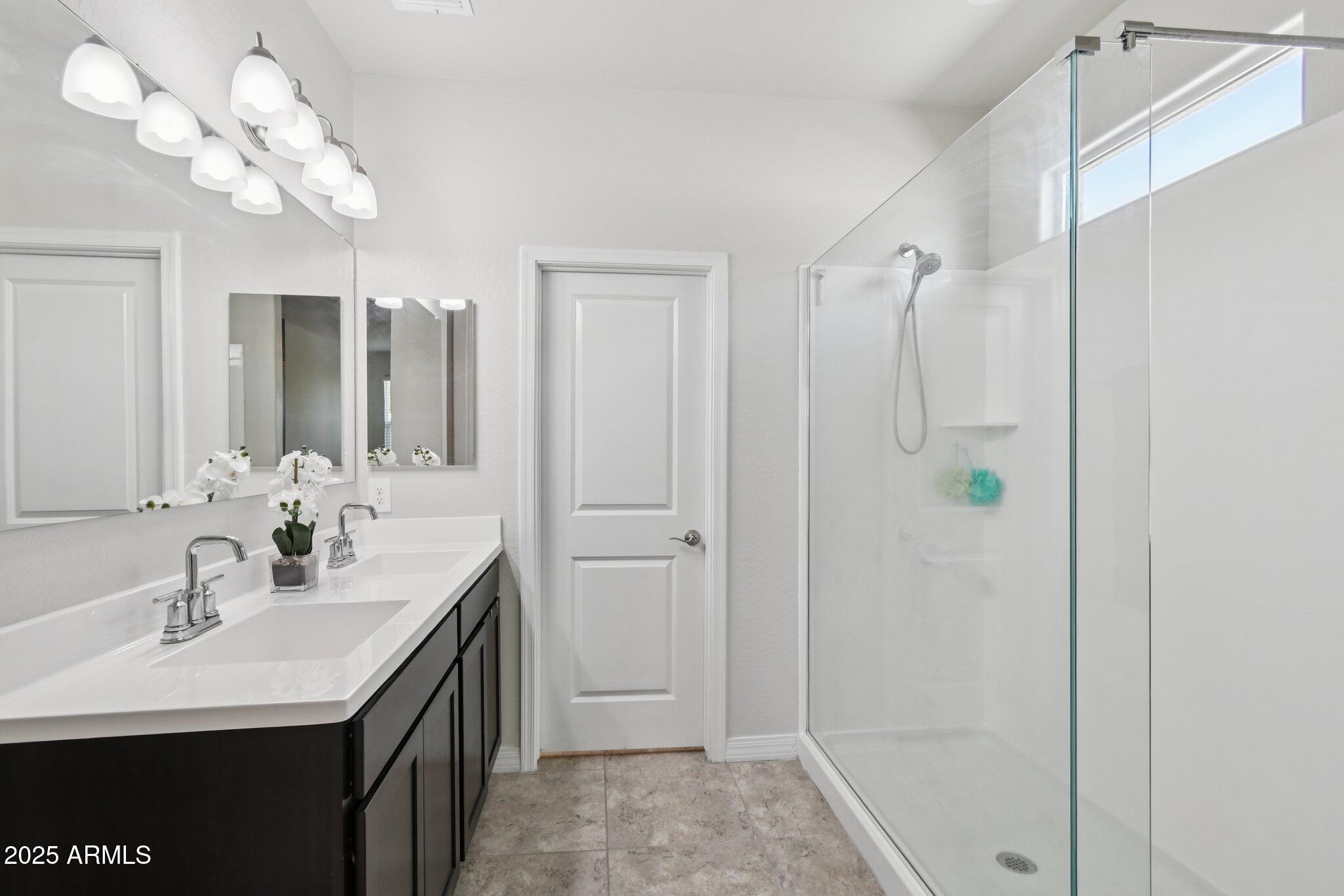 18819 West Farmer Road Buckeye, AZ 85326 - Photo 9 of 23 a bathroom with a sink a mirror and shower