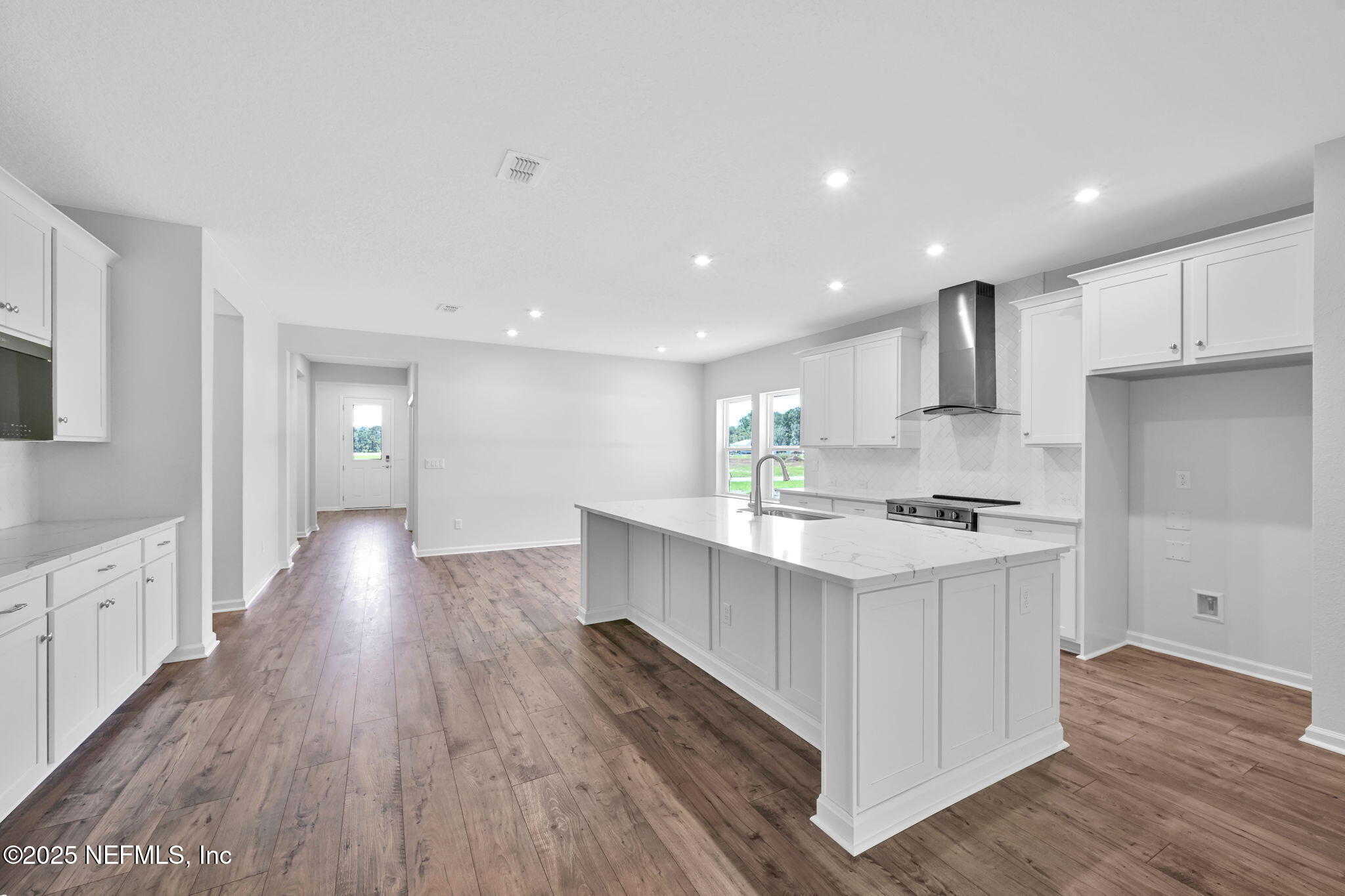 97003 Mcgirts Creek Loop Yulee, FL 32097 - Photo 13 of 40 a large kitchen with stainless steel appliances lots of counter space and wooden floor