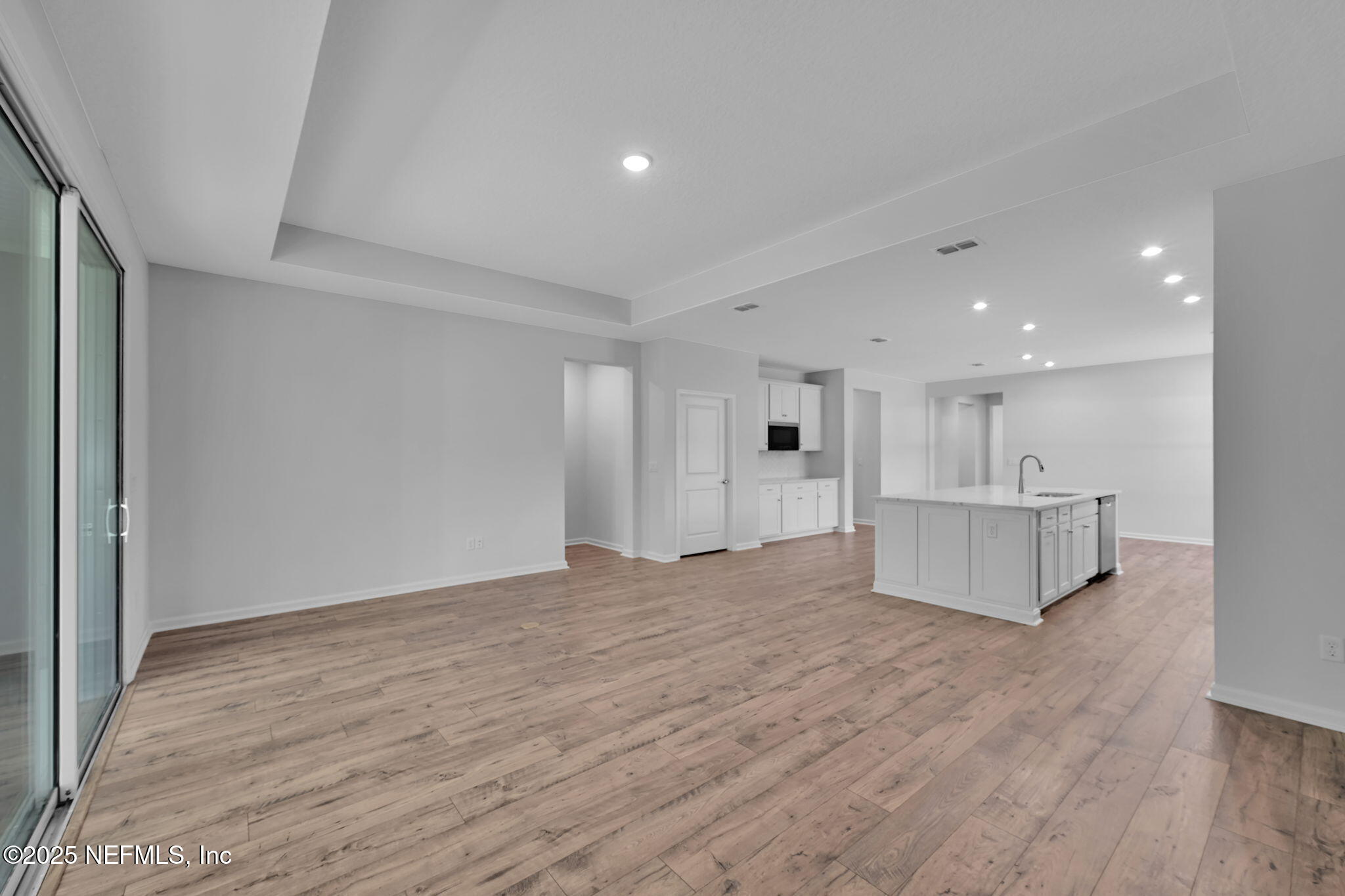 97003 Mcgirts Creek Loop Yulee, FL 32097 - Photo 15 of 40 a view of a kitchen with kitchen island white cabinets and wooden floor
