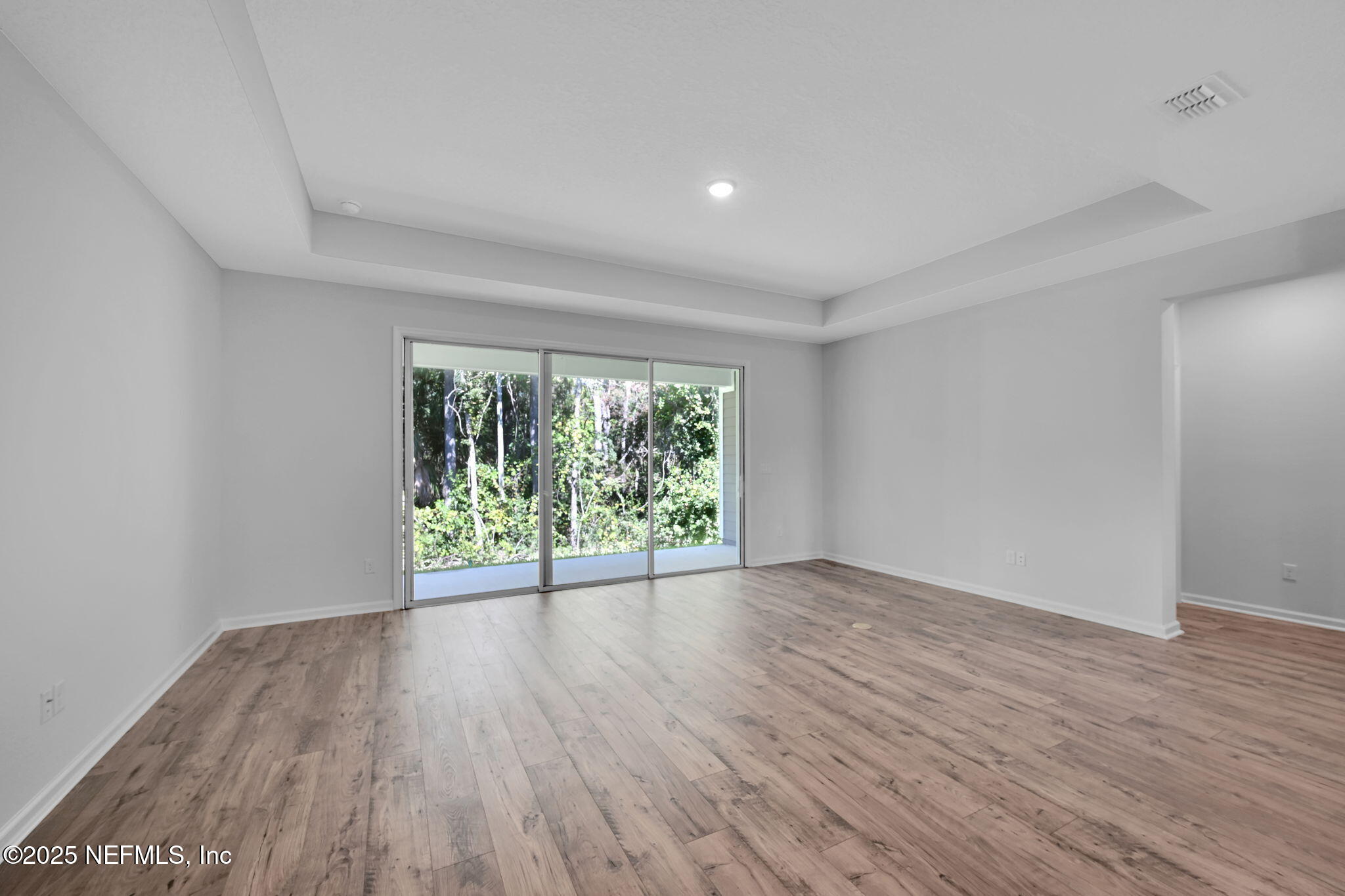 97003 Mcgirts Creek Loop Yulee, FL 32097 - Photo 16 of 40 a view of an empty room with wooden floor and a window