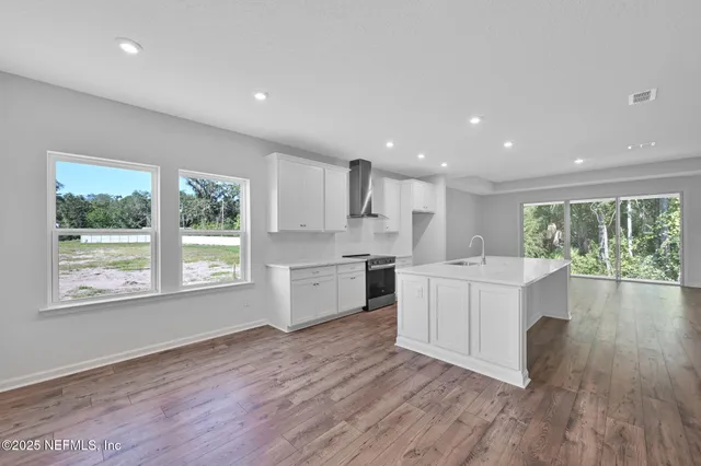 a kitchen with a sink wooden floor and white cabinets