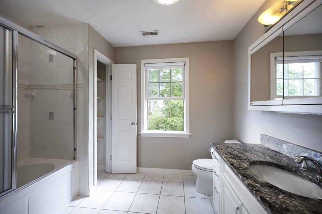 54 Spruce Street Winchester, MA 01890 - Photo 13 of 29 a bathroom with a granite countertop sink a toilet and shower