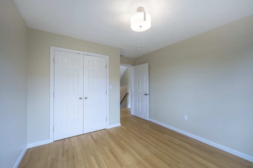 54 Spruce Street Winchester, MA 01890 - Photo 20 of 29 a view of a room with wooden floor and white walls