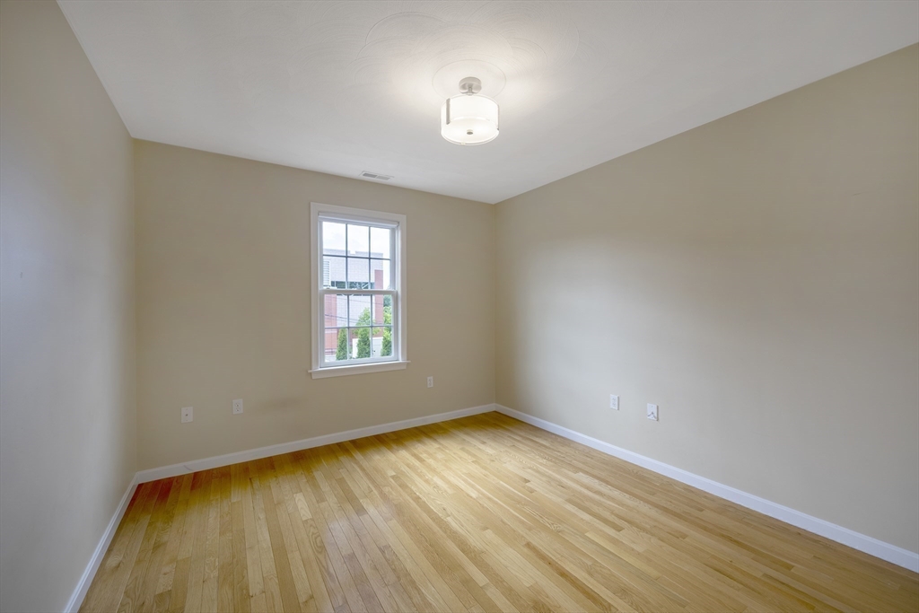 54 Spruce Street Winchester, MA 01890 - Photo 23 of 29 wooden floor in an empty room with a window