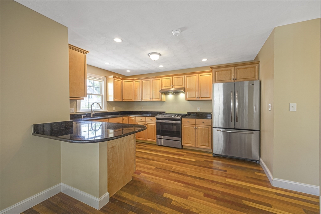 54 Spruce Street Winchester, MA 01890 - Photo 3 of 29 a kitchen with kitchen island a sink and wooden floor