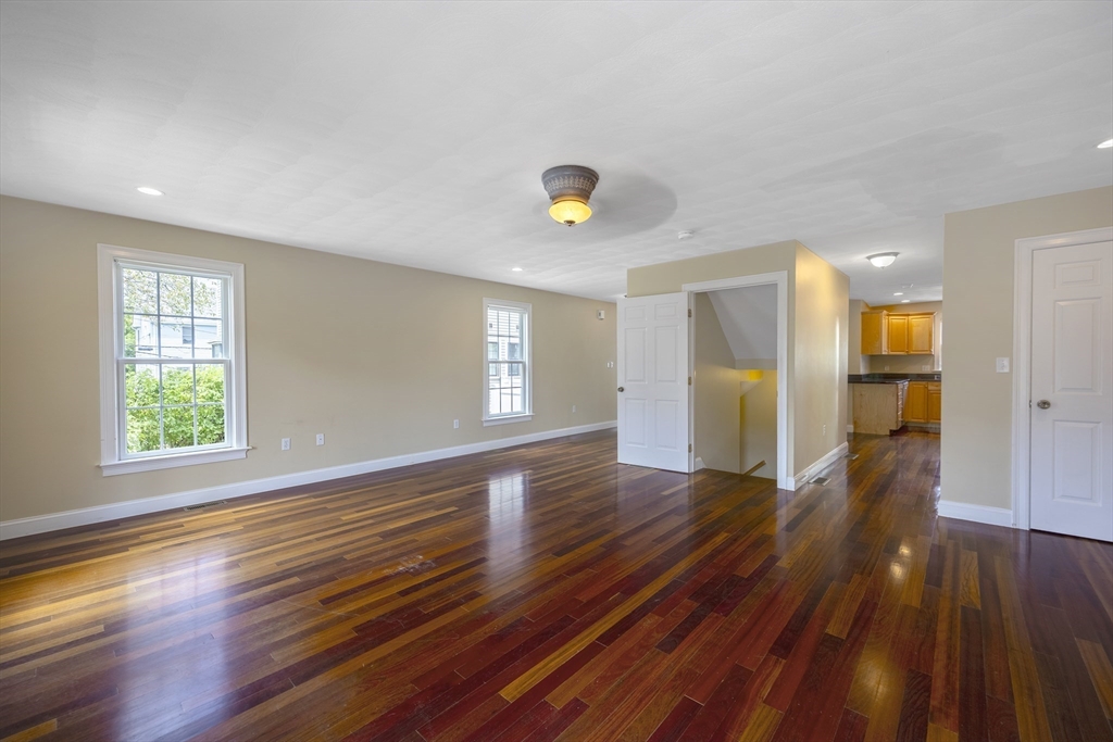 54 Spruce Street Winchester, MA 01890 - Photo 5 of 29 a view of an empty room with wooden floor and a window