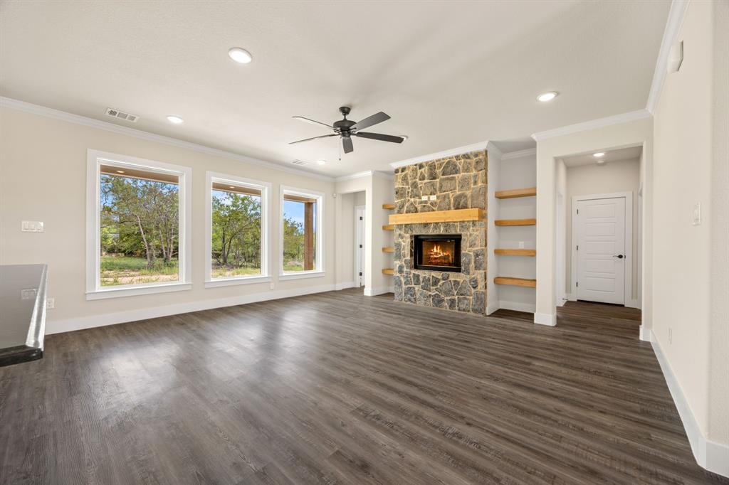 Lot 5 Slate Rock Road Ennis, TX 75119 - Photo 13 of 22 an empty room with fireplace wooden floor and windows