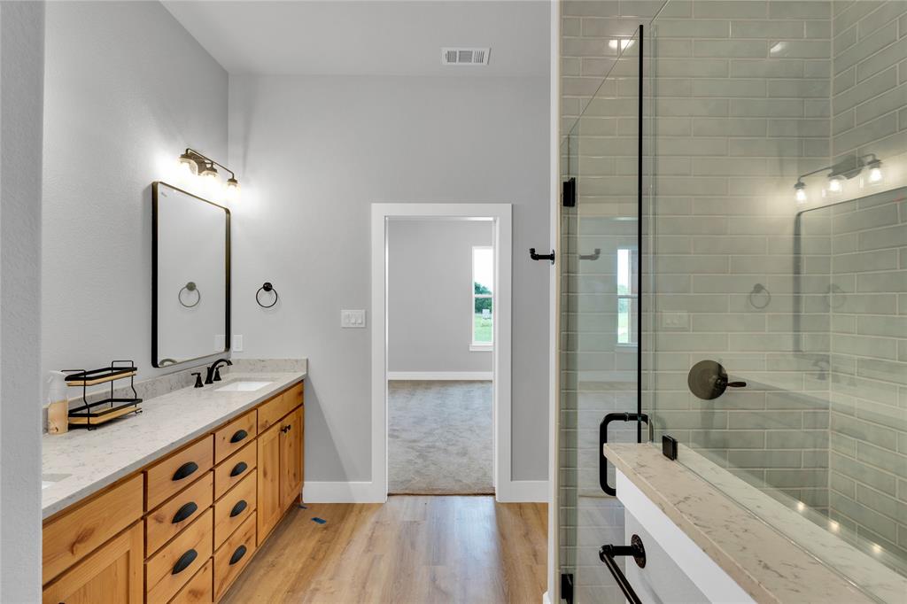 Lot 5 Slate Rock Road Ennis, TX 75119 - Photo 18 of 22 a bathroom with a double vanity sink a mirror and a bathtub