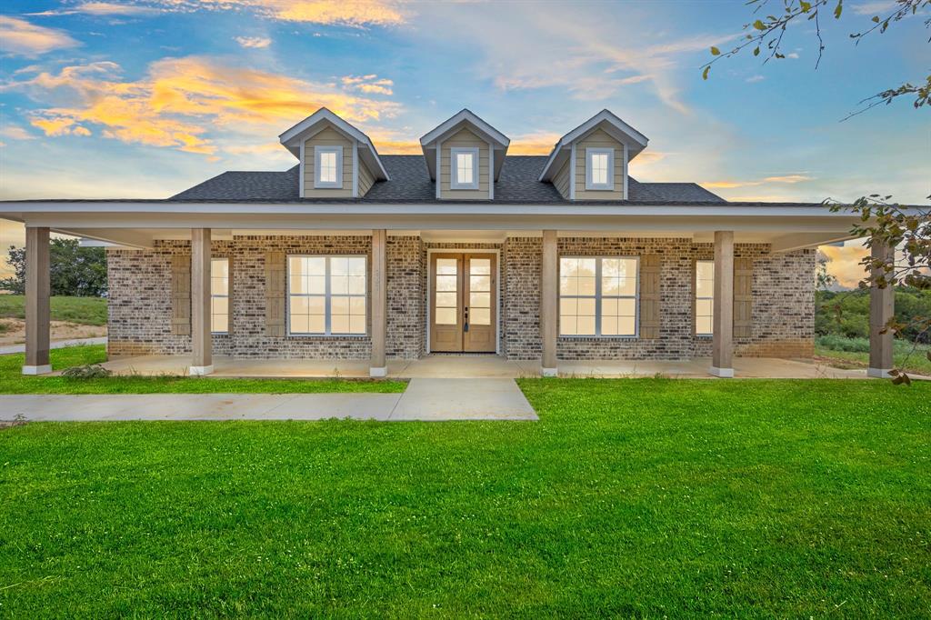 Lot 5 Slate Rock Road Ennis, TX 75119 - Photo 5 of 22 a front view of a house with a yard and balcony