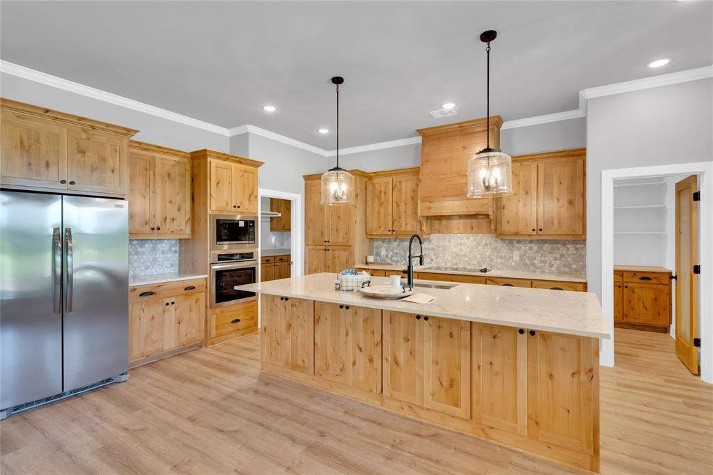 Lot 5 Slate Rock Road Ennis, TX 75119 - Photo 9 of 22 a large kitchen with kitchen island a large counter top stainless steel appliances and wooden floor