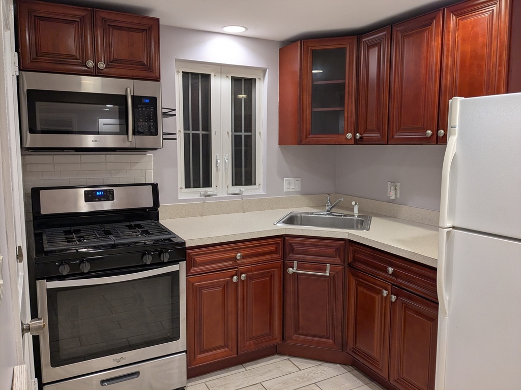 33 Paragon Road, Unit 1 Boston, MA 02132 - Photo 18 of 18 a kitchen with granite countertop wooden cabinets and stainless steel appliances