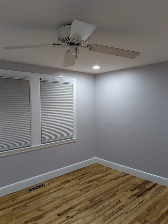 33 Paragon Road, Unit 1 Boston, MA 02132 - Photo 8 of 18 en empty room with wooden floor fan and windows