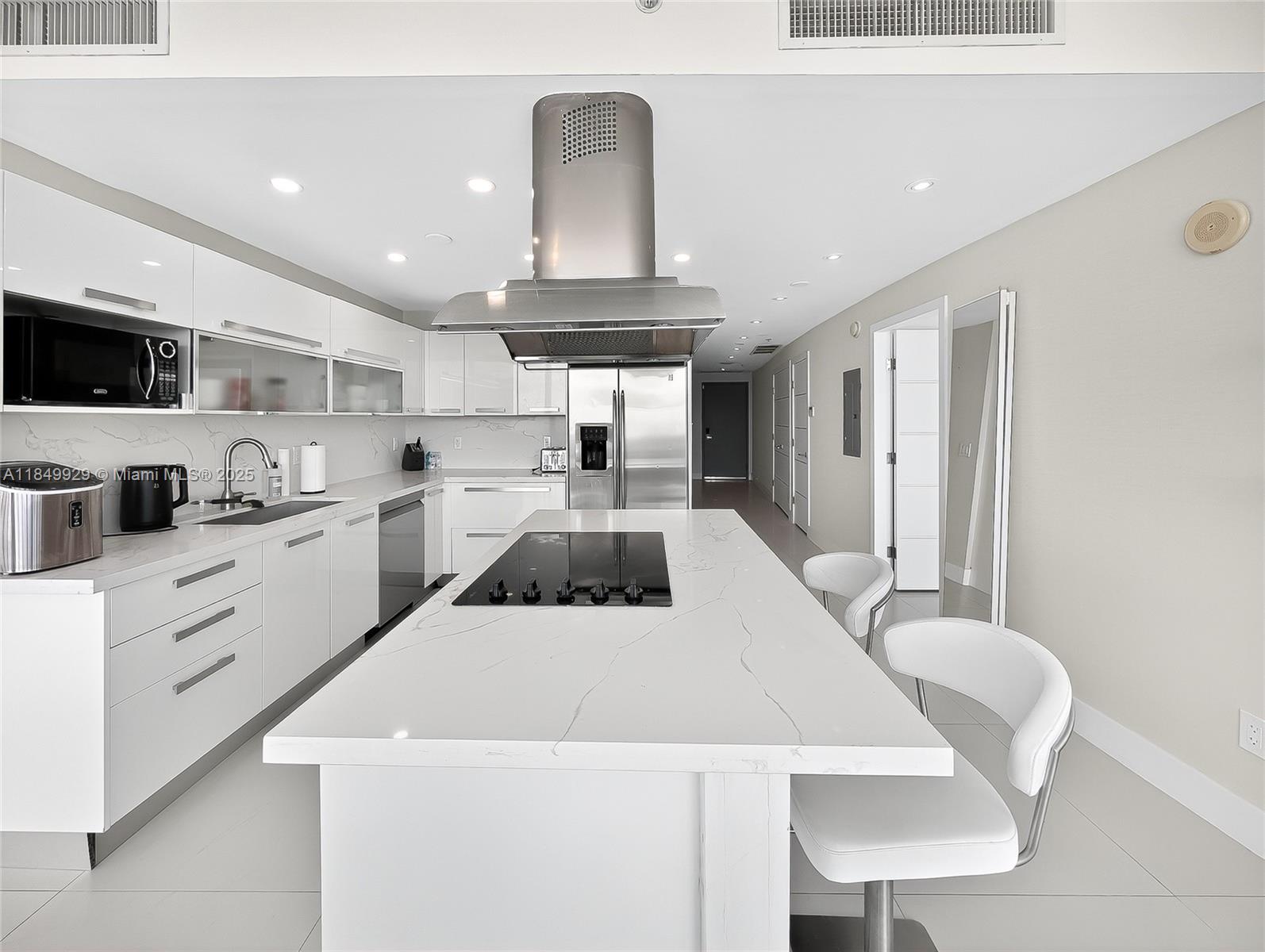 601 Northeast 36th Street, Unit 2201 Miami, FL 33137 - Photo 4 of 42 a kitchen with stainless steel appliances kitchen island granite countertop a sink a stove a refrigerator cabinets and a dining table