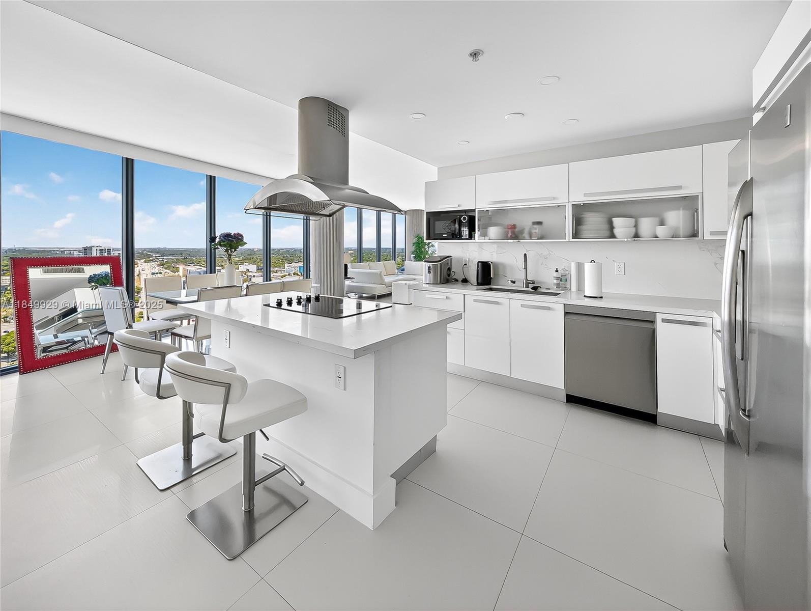 601 Northeast 36th Street, Unit 2201 Miami, FL 33137 - Photo 5 of 42 a kitchen with stainless steel appliances a sink a stove a refrigerator cabinets and dining table