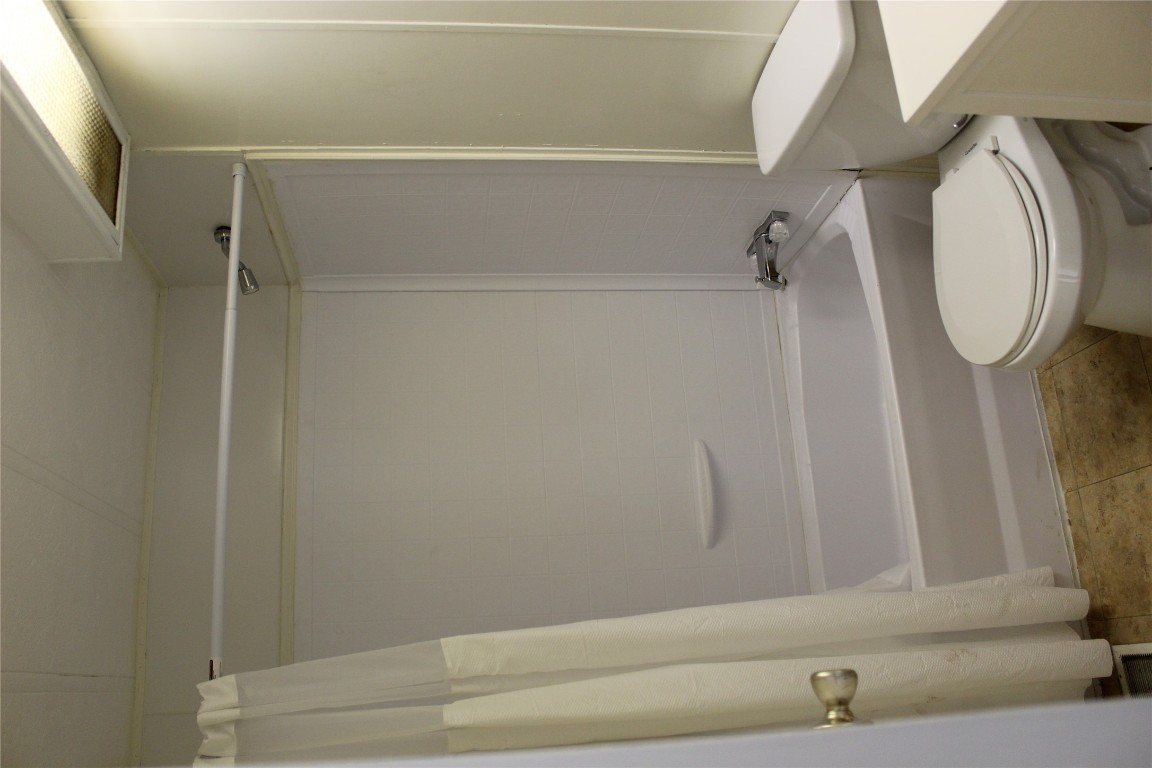 14111 South Green Hills Loop, Unit B Austin, TX 78737 - Photo 6 of 13 a bathroom with a toilet and a bathtub