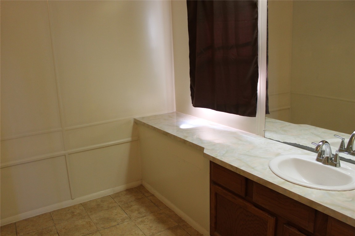 14111 South Green Hills Loop, Unit B Austin, TX 78737 - Photo 10 of 13 a bathroom with a sink and a mirror
