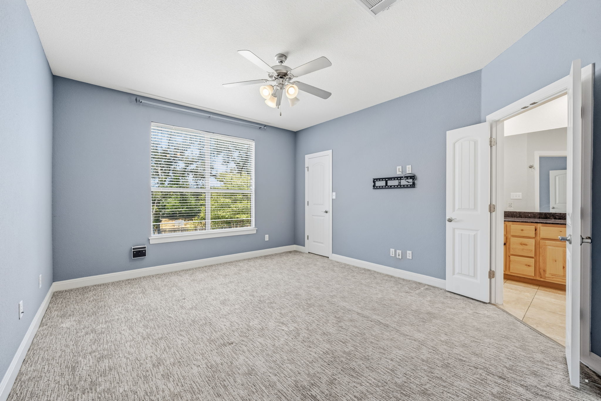 6708 Manchaca Road, Unit 4 Austin, TX 78745 - Photo 15 of 25 Plush carpeting and an open doorway leading to an en suite bathroom define this space.