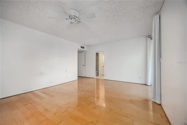 a view of empty room with wooden floor
