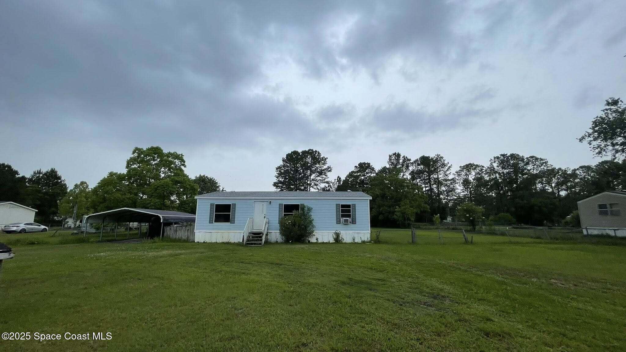 54275 Bea Road Callahan, FL 32011 - Photo 2 of 52 a view of a white house with a yard and a large tree