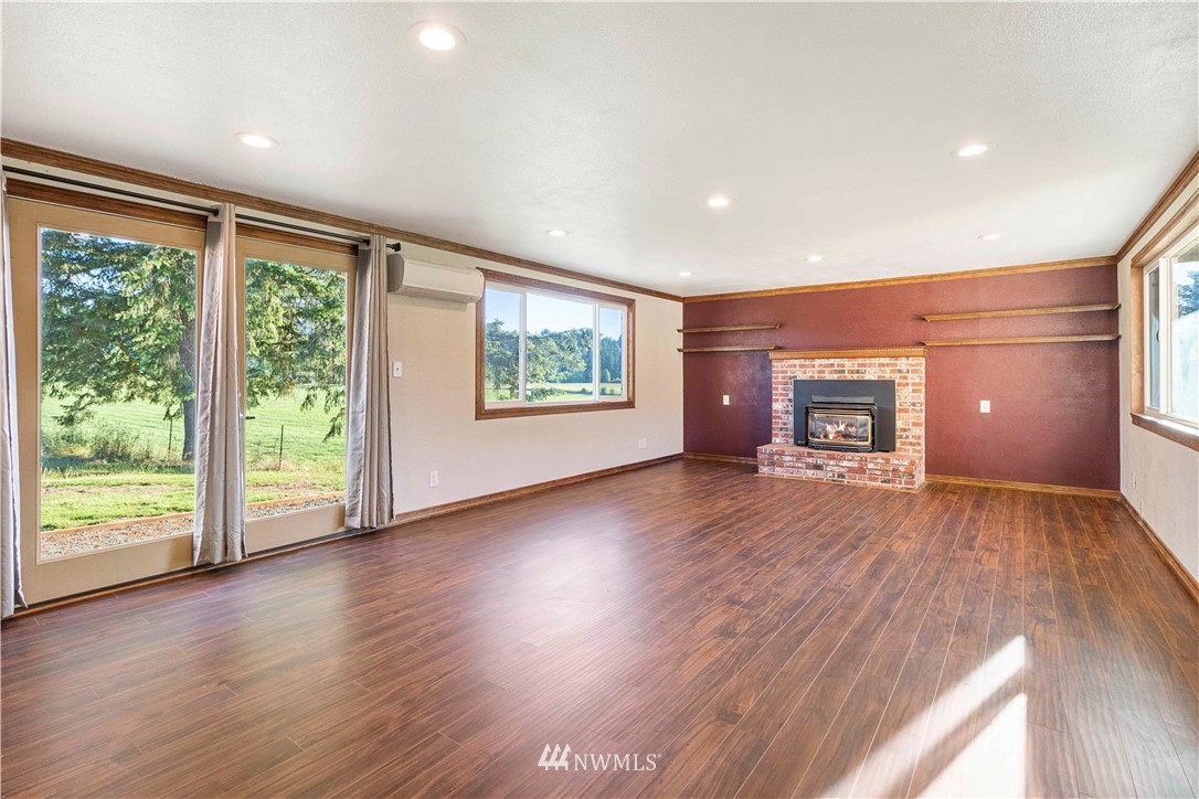 10101 James Road Southwest Rochester, WA 98579 - Photo 14 of 34 a view of empty room with wooden floor and fireplace