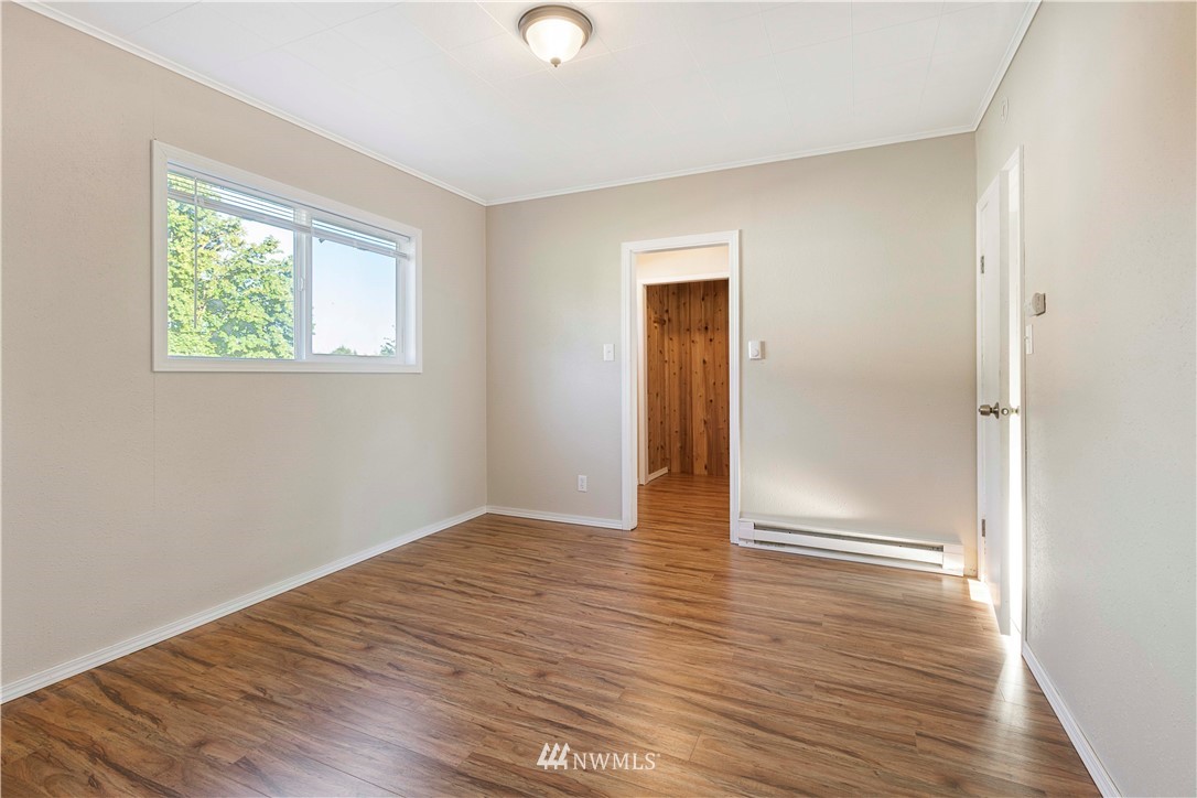 10101 James Road Southwest Rochester, WA 98579 - Photo 19 of 34 an empty room with wooden floor and windows