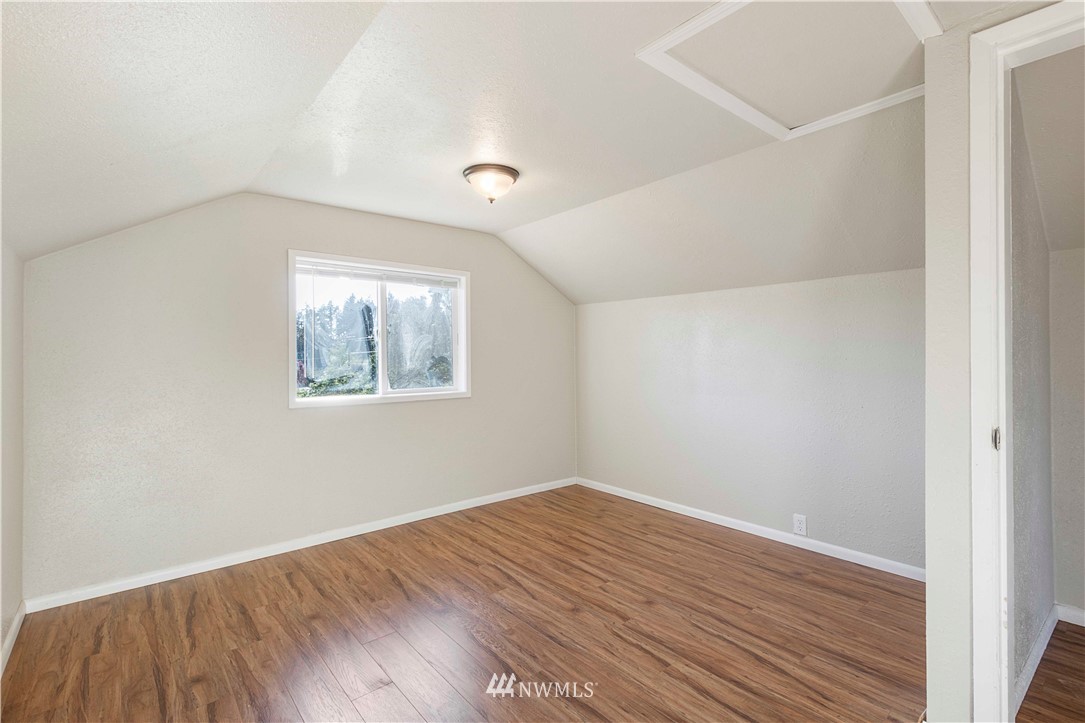 10101 James Road Southwest Rochester, WA 98579 - Photo 21 of 34 an empty room with wooden floor and windows