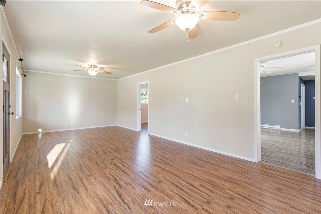 10101 James Road Southwest Rochester, WA 98579 - Photo 10 of 34 a view of an empty room with wooden floor and a ceiling fan