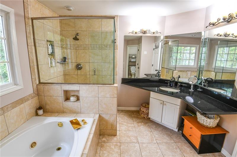 1865 Oak Tree Hollow Alpharetta, GA 30005 - Photo 17 of 35 a bathroom with a tub sink and mirror