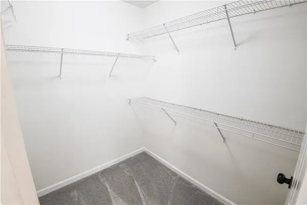 an empty room with a chandelier fan and closet