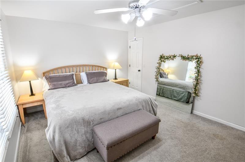 1865 Oak Tree Hollow Alpharetta, GA 30005 - Photo 20 of 35 a bedroom with a bed and ceiling fan