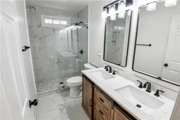 a view of a bedroom with wooden floor and a ceiling fan