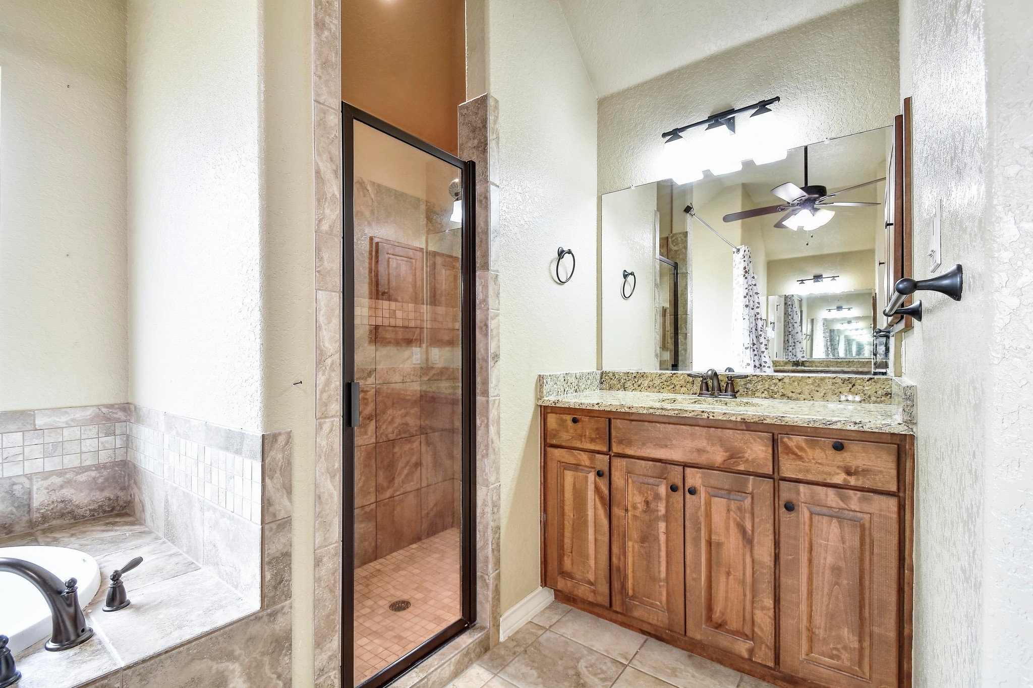158 Pullman Road La Vernia, TX 78121 - Photo 21 of 39 a bathroom with a granite countertop sink two mirror and a shower