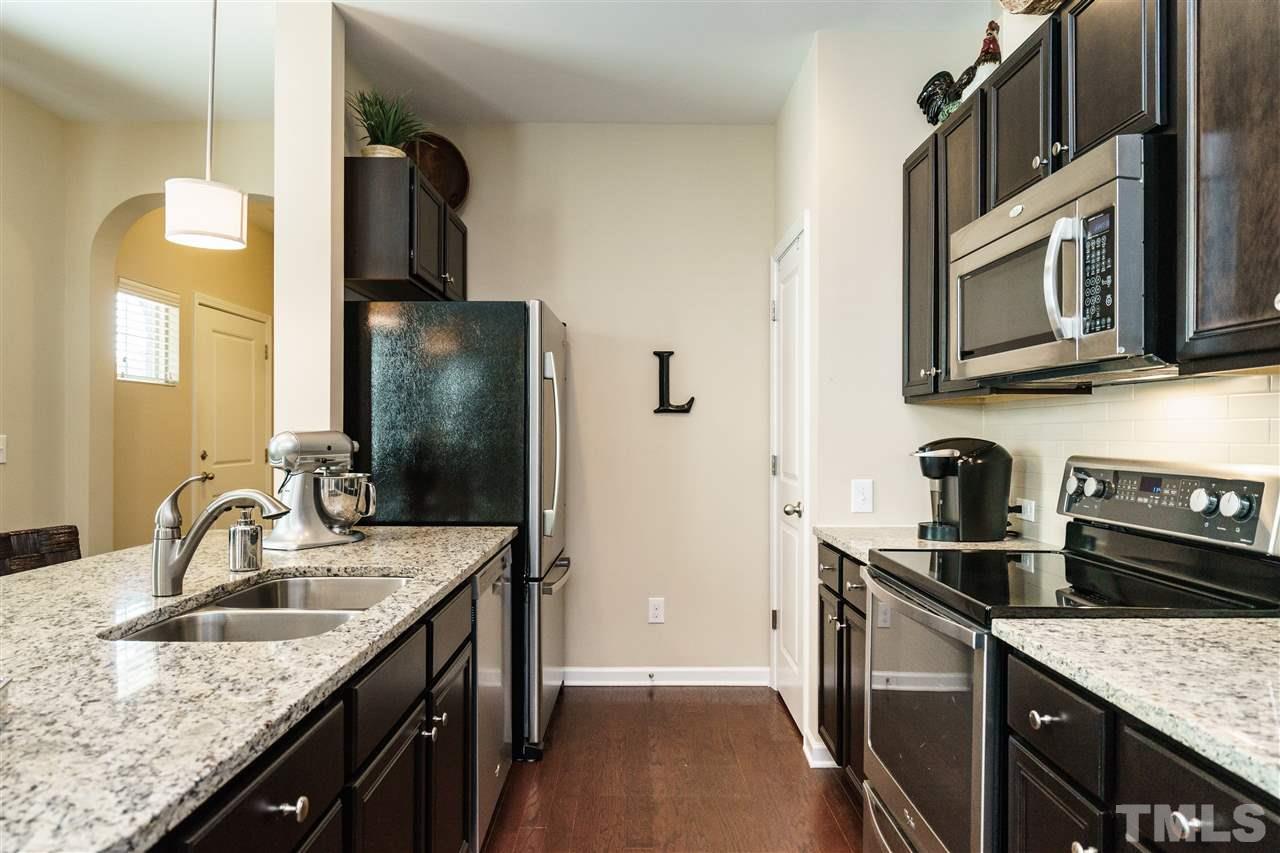 756 Wickham Ridge Road Apex, NC 27539 - Photo 14 of 25 a kitchen with stainless steel appliances granite countertop a sink stove and refrigerator
