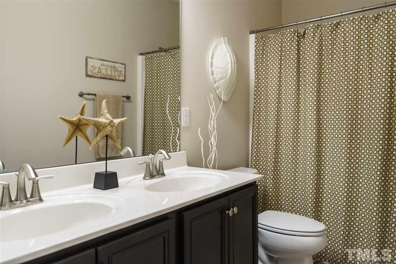 756 Wickham Ridge Road Apex, NC 27539 - Photo 22 of 25 a bathroom with a sink vanity mirror and toilet