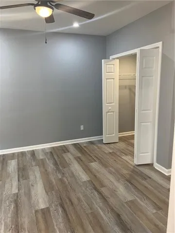 a view of a hallway with wooden floor and cabinets