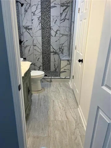 a bathroom with a toilet sink and mirror